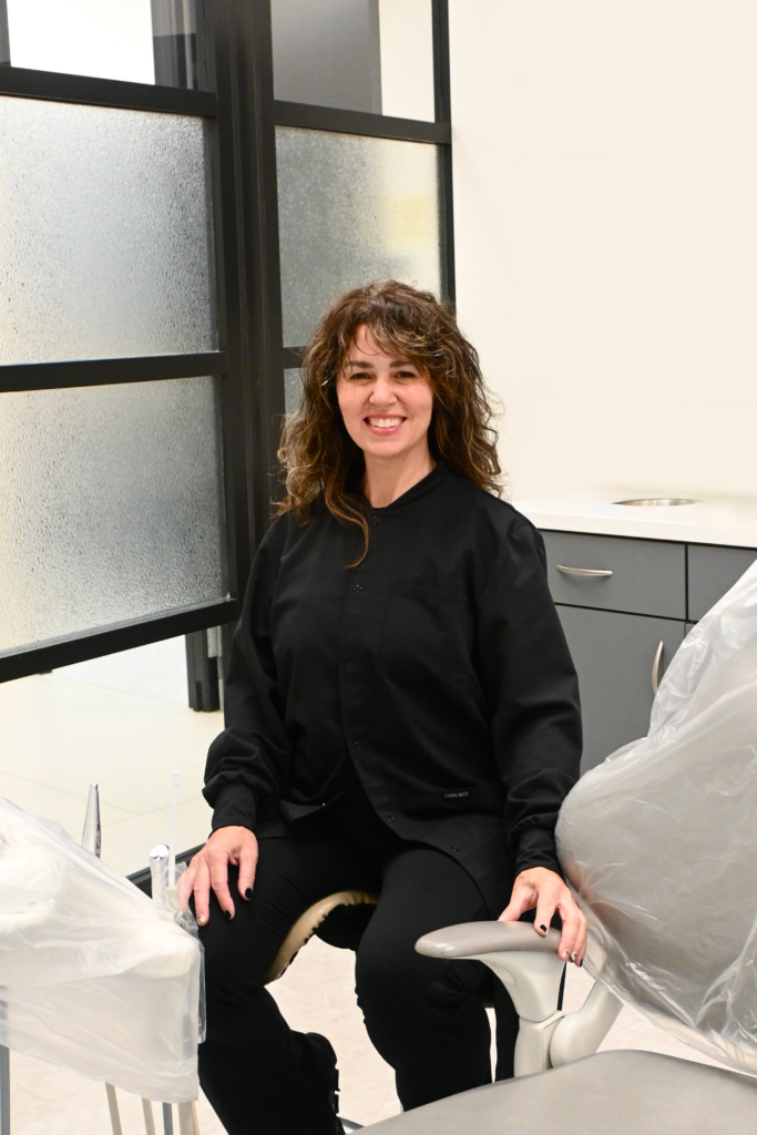 Mary Wall sitting in a modern treatment room at NC Implants and Periodontics.