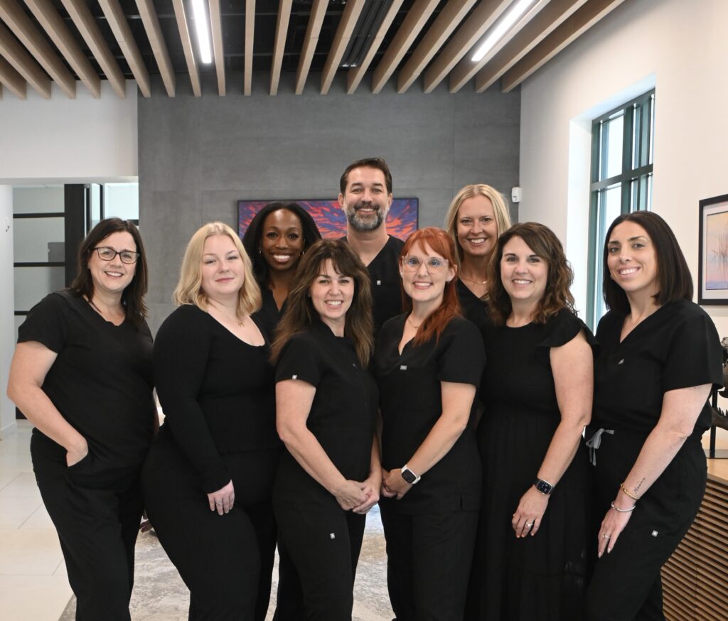 The periodontics and dental implant team standing together in the office lobby at NC Implants and Periodontics.